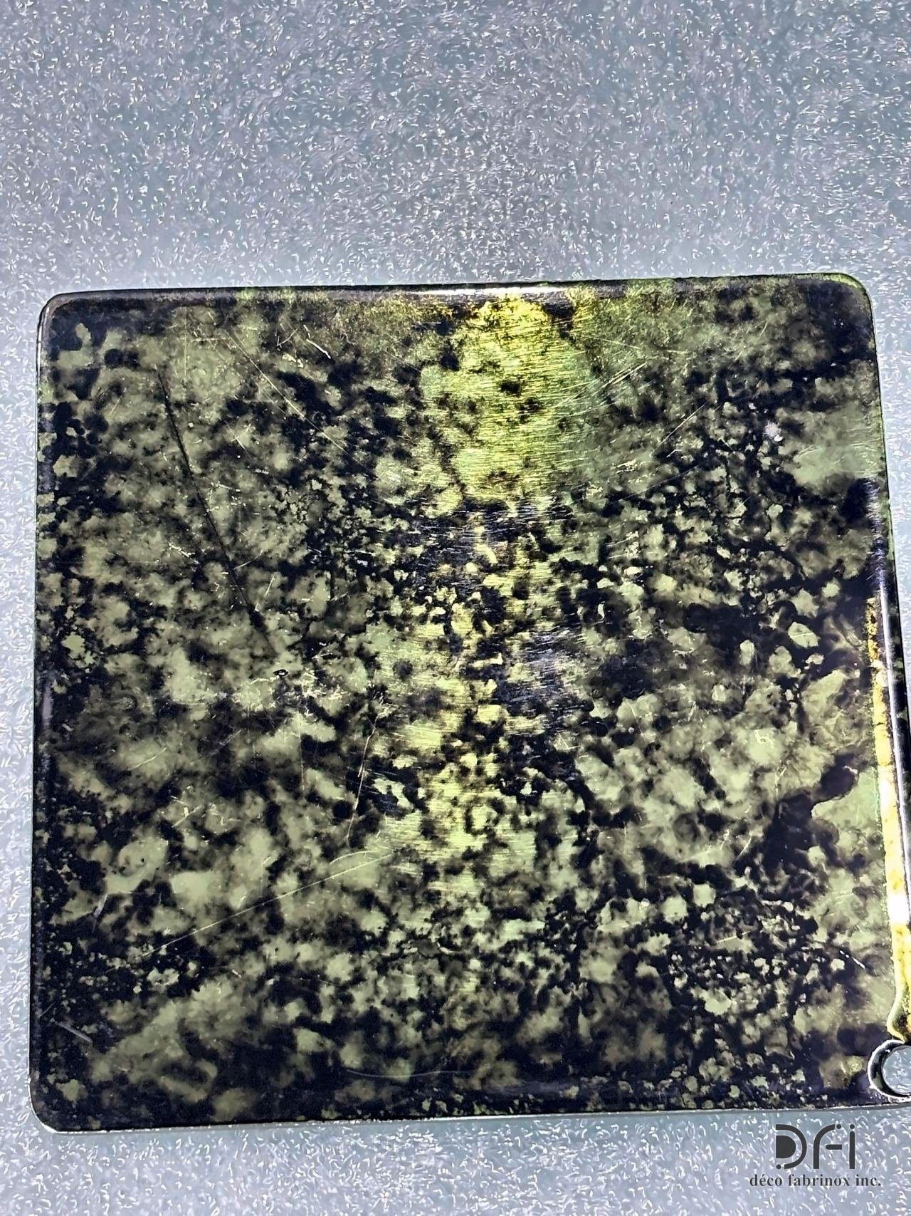 Black and gold mottled patina on a metal sample