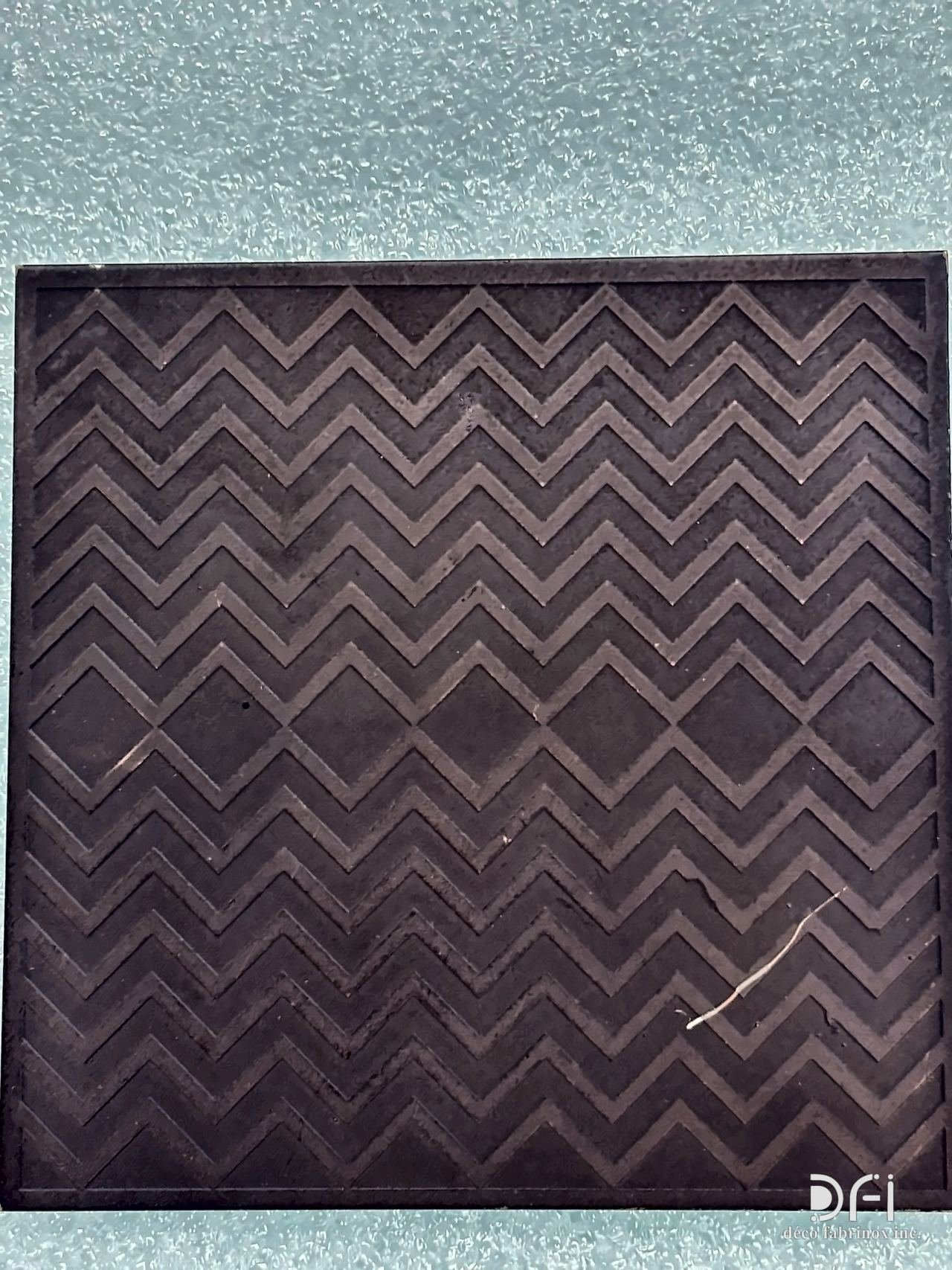 Etched chevron pattern on a dark metal sample