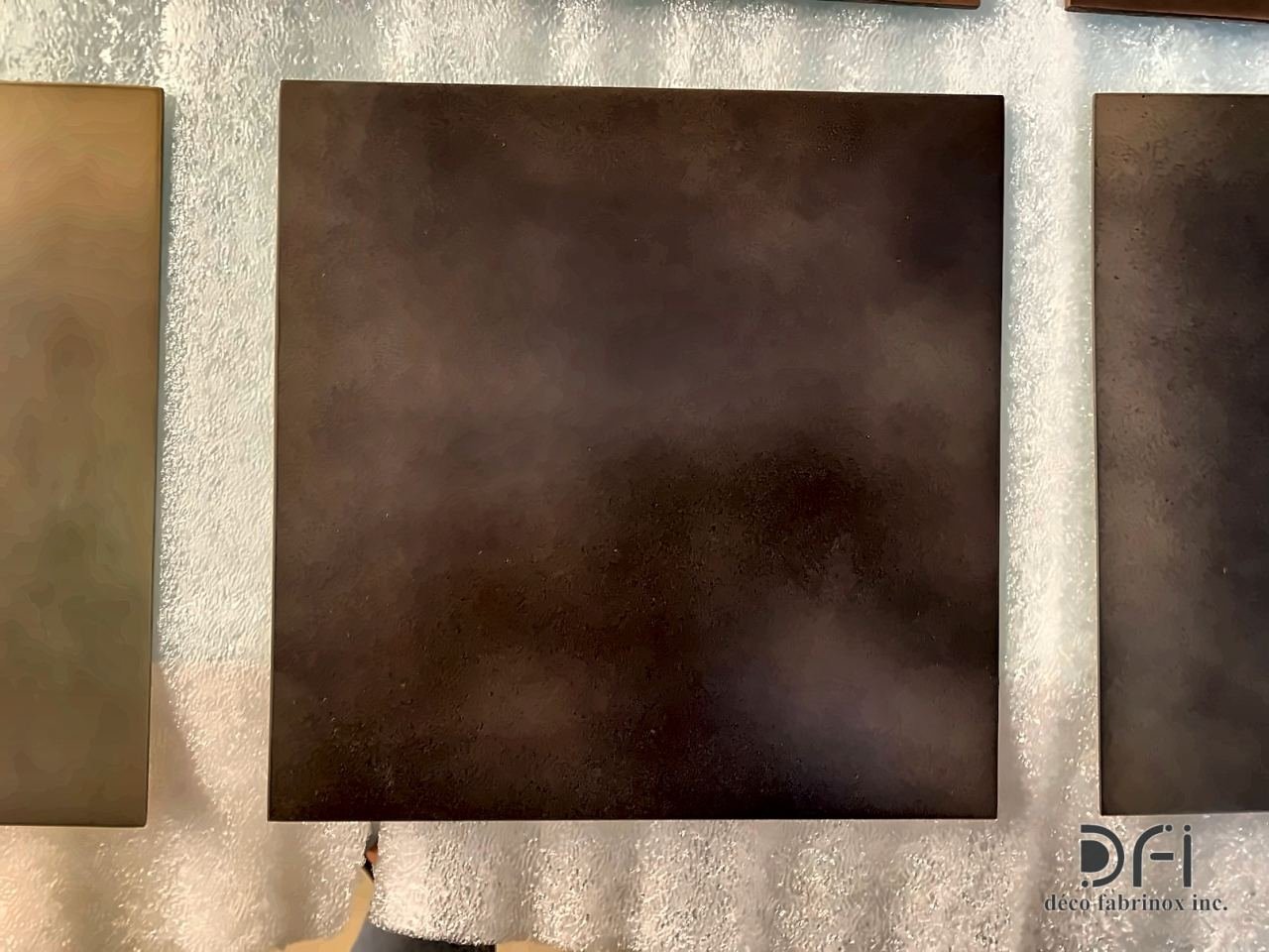 Dark bronze brushed finish on a square metal sample